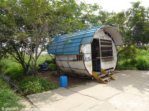 Kiosk made from a cylindrical tank with blue roof, under trees