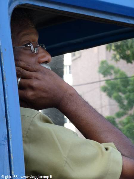 Driver with glasses and white beard, pensive at the window of a blue van