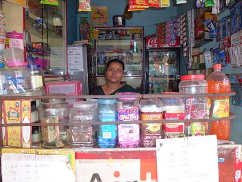 Woman behind the counter of a small shop with candy jars