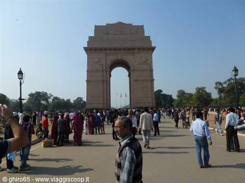 Crowds of tourists walk in front of India Gate, New Delhi, in daylight