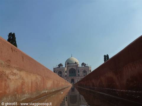 Water channel between red walls leading to Humayun's Tomb, blue sky