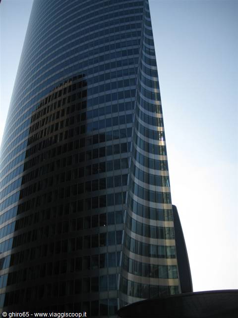 Curved glass EDF Tower in La Défense, morning light reflections