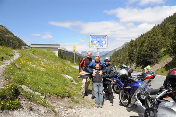 {"it": "Gruppo di motociclisti colMimeType"}
Let me correct: {"it": "Quattro motociclisti accanto alla loro moto al passo Fuorn, 2149 metri", "en": "Four motorcyclists posing by their bikes at Pass dal Fuorn, 2149 meters"}