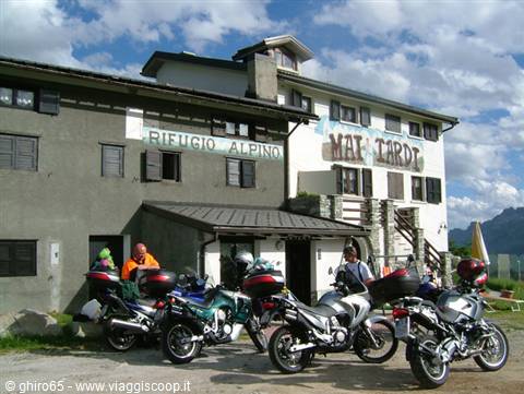 Motorcyclists stopped in front of the Mai Tardi alpine refuge in the mountains
