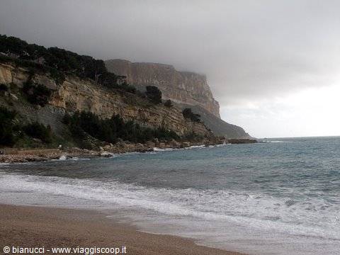 Cap Canaille cliffs under clouds above Cassis beach