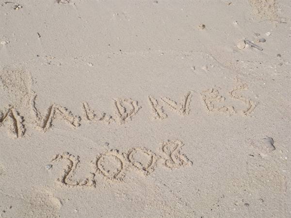 Maldives 2008 written by hand on the pale sand of the beach
