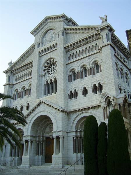 Monaco Cathedral, white stone facade framed by palm and cypresses