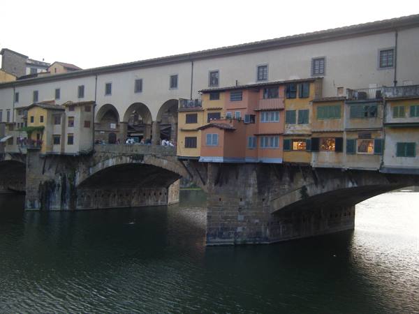 Ponte Vecchio in Florence, colorful shops on stone arches over the Arno