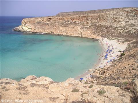 Rabbit Beach in Lampedusa, white sand and turquoise water between limestone cliffs