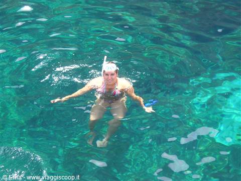 Woman with snorkel mask swimming in clear turquoise water