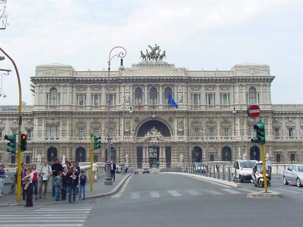 Pedestrians crossing the street in front of Rome's Palace of Justice