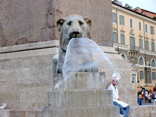 Marble lion fountain at Piazza del Popolo, man in costume sitting beside