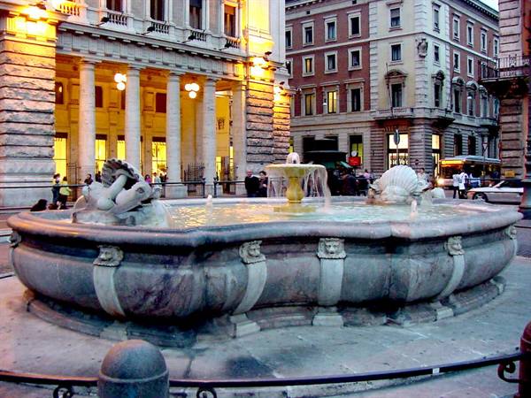 Marble fountain in front of the illuminated theatre in Palermo