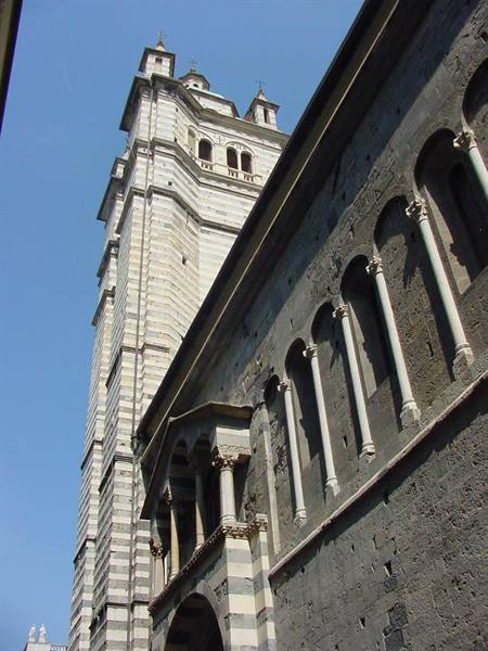Striped white and grey bell tower beside the Romanesque nave of Genoa Cathedral