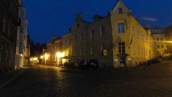 Cobbled square with historic buildings lit by street lamps at night