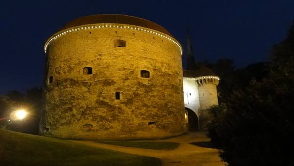 Fat Margaret tower lit at night in Tallinn, medieval stone walls