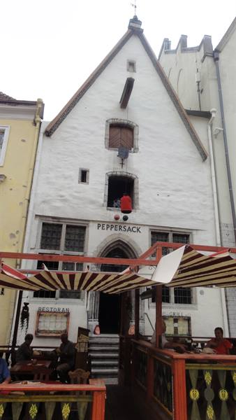 White medieval facade of Peppersack restaurant with striped awnings