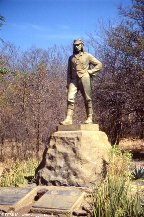 Bronze statue of David Livingstone on rock among dry trees at Victoria Falls