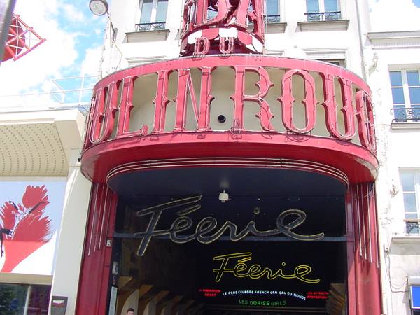Red Moulin Rouge sign in Paris with neon Fée signs