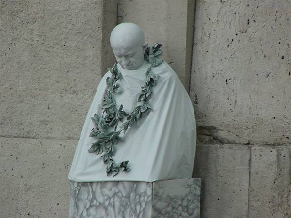 White marble bust of Pope John Paul II wearing laurel wreath on pedestal