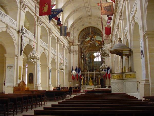 Saint-Louis des Invalides cathedral in Paris, nave with flags and lit altar