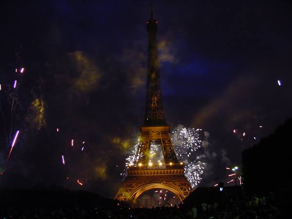 Fireworks around the illuminated Eiffel Tower at night