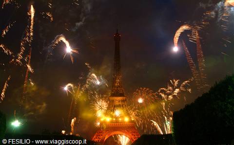 Golden fireworks burst around the illuminated Eiffel Tower at night
