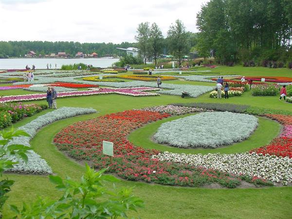 Spiral flowerbeds in the blooming gardens of Mainau, visitors walking among flowers