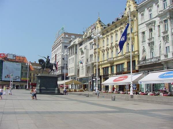 Equestrian statue on Zagreb's pedestrian square, historic buildings, cafes, blue flag