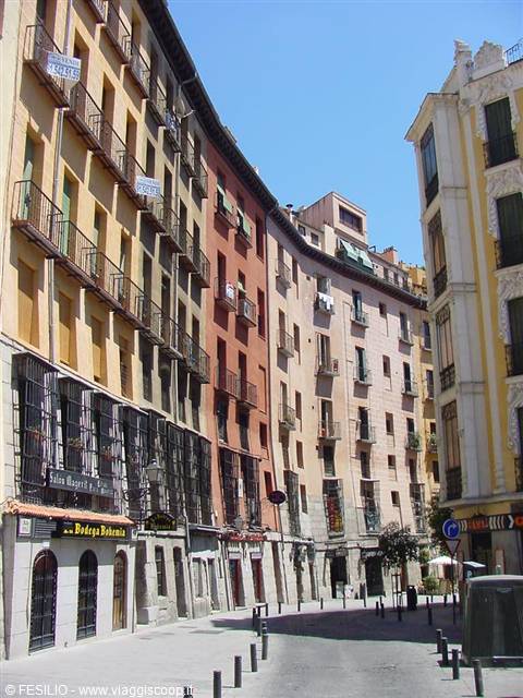 Colorful buildings with balconies along empty Madrid street in sunlight