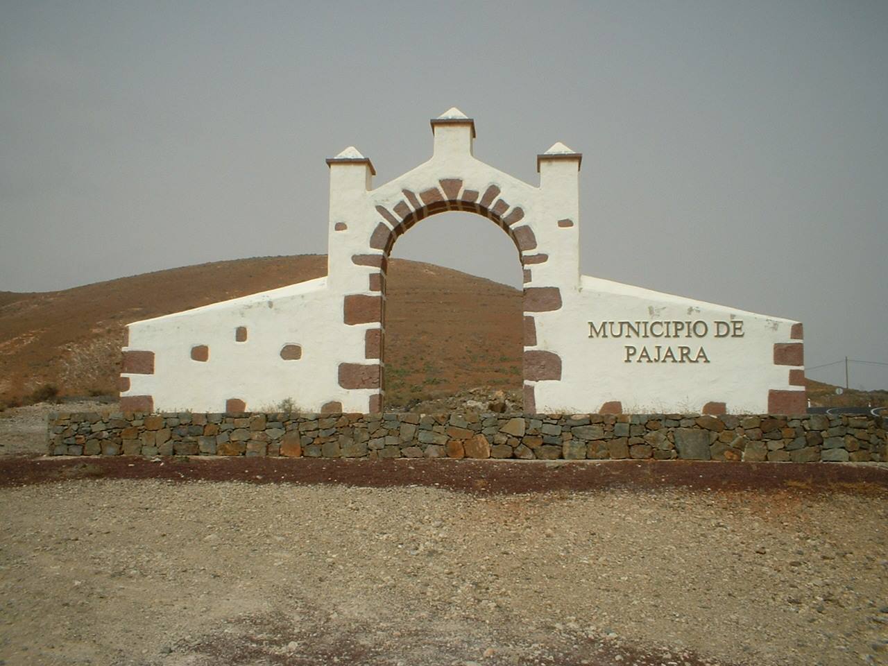 White stone arch reading Municipio de Pajara amid arid hills