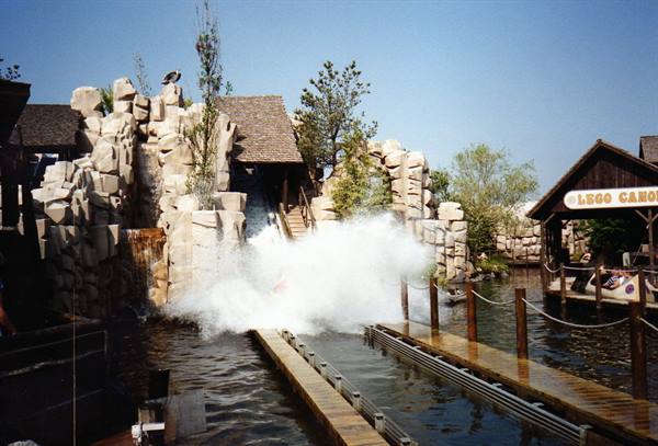 Big water splash on a flume ride among fake rocks at Legoland
