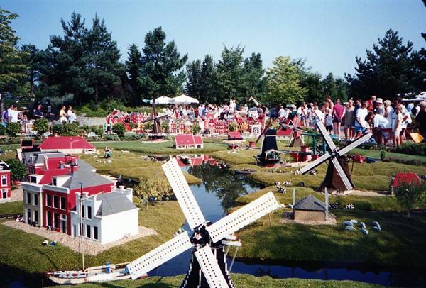 Brick windmills at Madurodam, visitors among miniature Dutch buildings