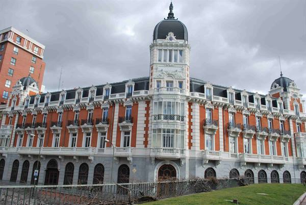Red brick and white palace in Madrid, domed tower, cloudy sky
