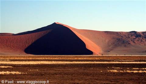 Red Sossusvlei dune with shadowed slope over sandy plain
