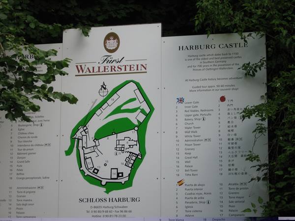 Information boards with Harburg Castle map surrounded by green tree leaves