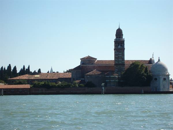 San Michele island in Venice: brick church and bell tower seen from the water