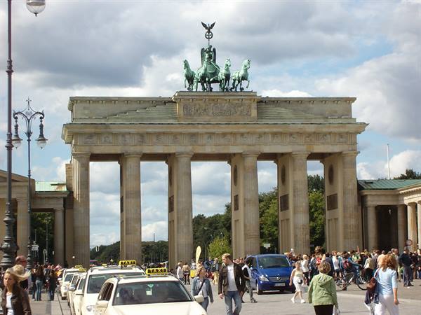 Brandenburg Gate in Berlin, taxis and tourists pass under the columns