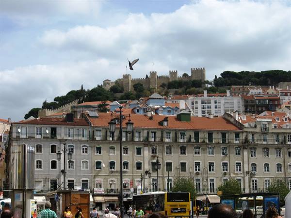 São Jorge Castle overlooks the tiled rooftops of Lisbon under cloudy skies