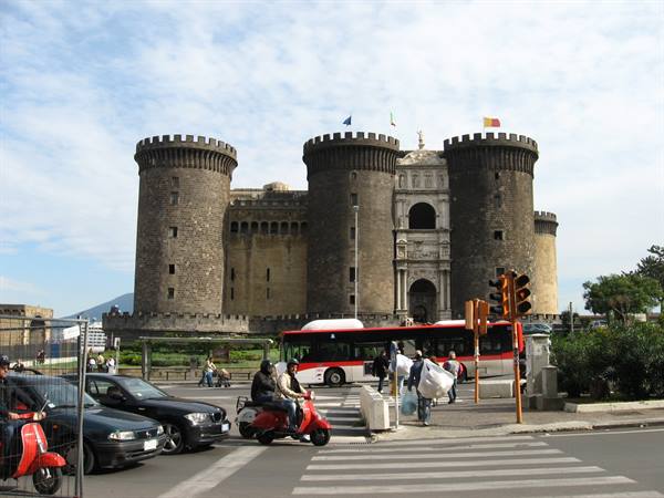 Castel Nuovo in Naples, traffic and pedestrians beneath the stone towers