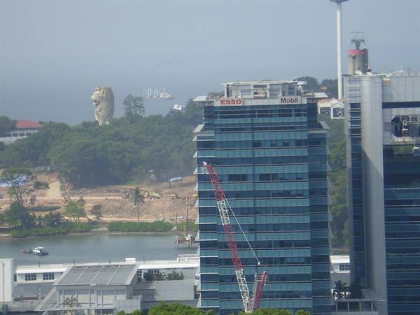 Office tower with Esso and Mobil signs, Sentosa Merlion among the trees