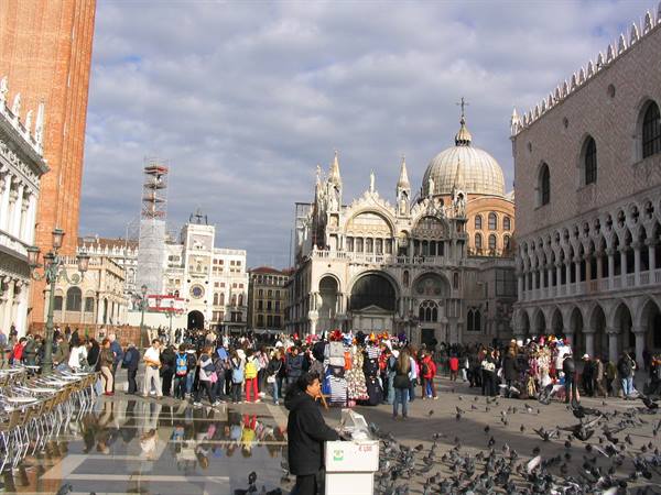 Tourists and pigeons in St Mark's Square, Venice, with Basilica and bell tower