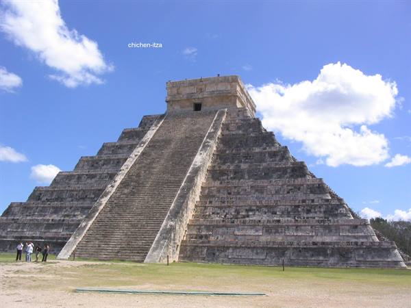 El Castillo pyramid at Chichen Itza, grey stone, tourists under blue sky
