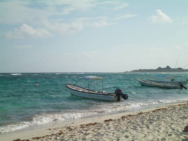 Fishing boats anchored near shore, pale sand and turquoise water