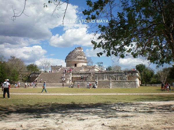 Tourists climb the stone staircase of the Maya observatory El Caracol under cloudy sky