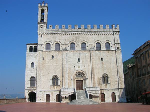 Palazzo dei Consoli in Gubbio, light stone facade, staircase, bell tower, blue sky