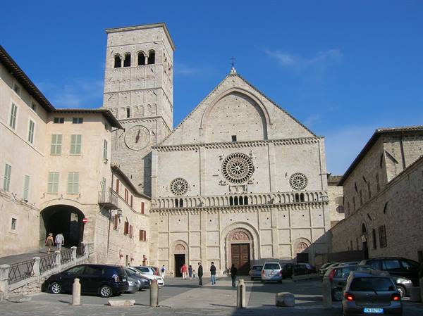 San Rufino Cathedral in Assisi, Romanesque facade with rose window, tourists and cars below