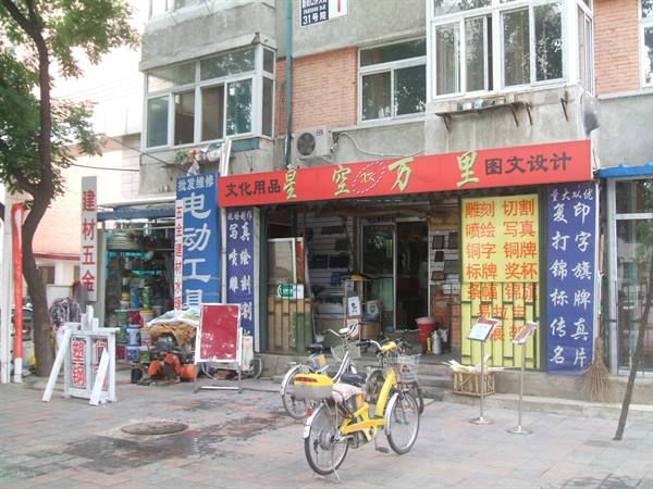 Yellow bicycle parked outside a shop with red Chinese signboards
