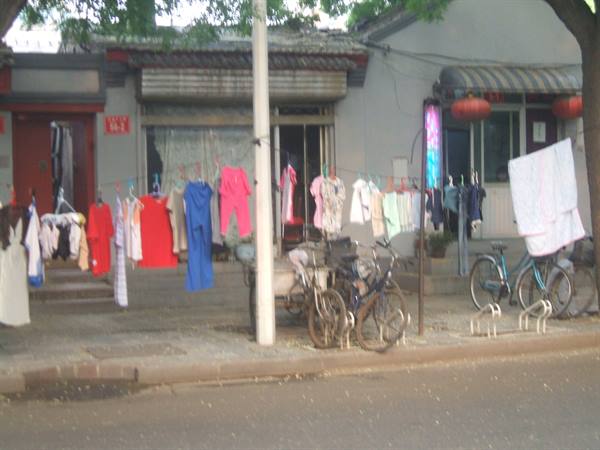 Laundry drying on a line outside a house in a Beijing hutong, parked bicycles