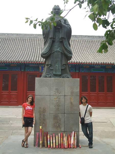 Two tourists beside the bronze Confucius statue at the temple